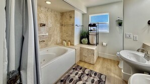 A modern bathroom with a bathtub, a sink, and a shower area. - Tranquil Desert Retreat | Pools & Hot Tub (St George)