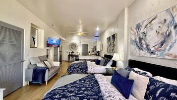 A hotel room with a bed, a sofa, a desk, and a television.