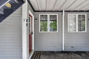 A house with a gray siding exterior, a red door, and a number '3' on the wall. - Riverbend Ski Retreat - Modern Condo minutes to Sunday River, Breweries & Bethel (Bethel)