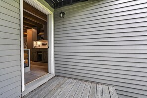 A wooden deck with a door leading to a kitchen area. - Riverbend Ski Retreat - Modern Condo minutes to Sunday River, Breweries & Bethel (Bethel)