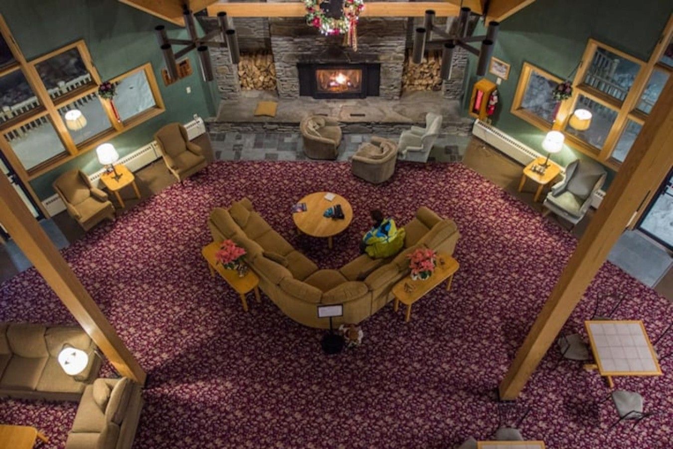 Um quarto aconchegante com lareira de pedra, um amplo sofá em formato de L e uma mesa de centro redonda.