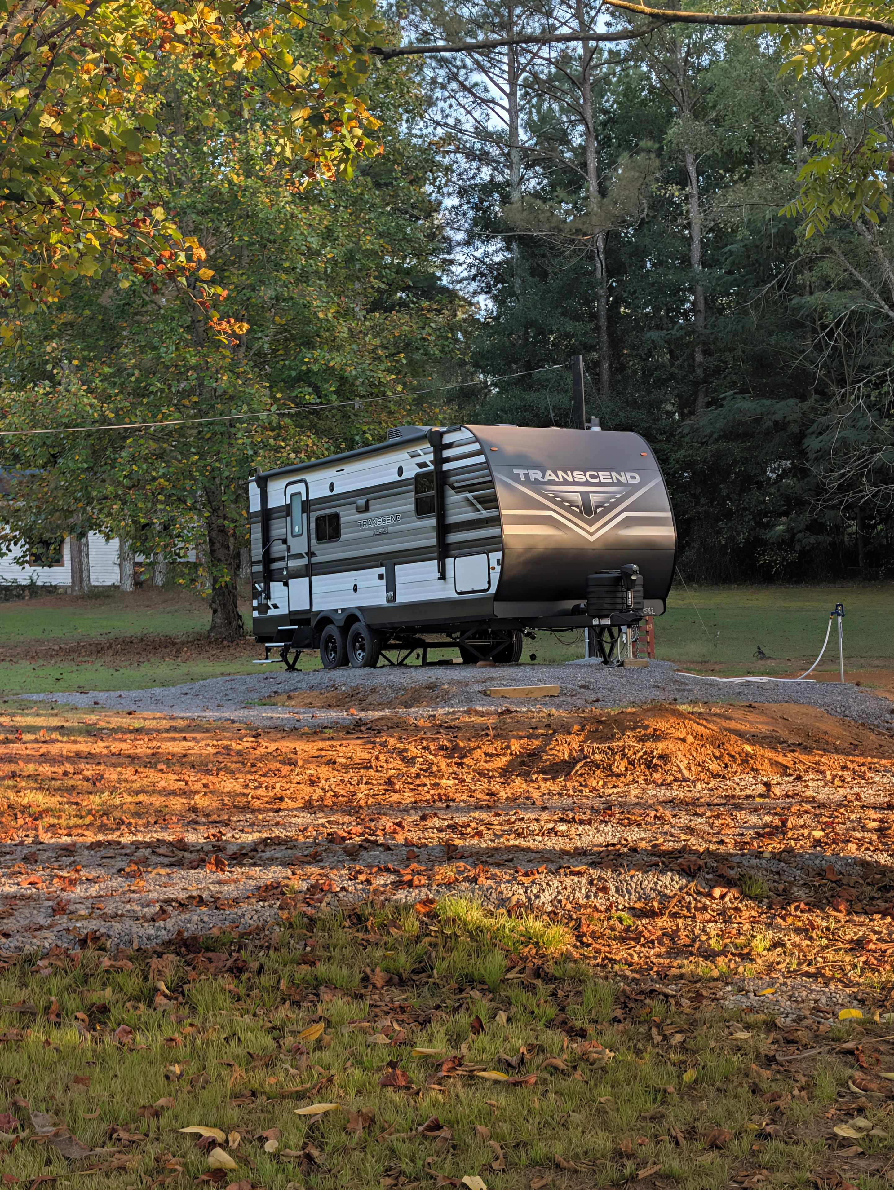 Uma motorhome Transcend estacionada numa área gramada, com árvores ao fundo.