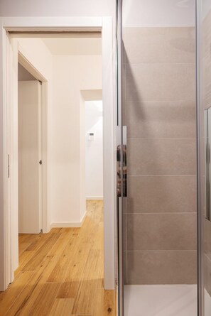 A modern bathroom with a glass shower enclosure and a wooden floor. - Quiet Central Flat, 2 Bedr 2 Bathrm + FREE Parking (Milano)