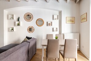 A modern living room with a sofa, dining table, chairs, and decorative mirrors. - Quiet Central Flat, 2 Bedr 2 Bathrm + FREE Parking (Milano)