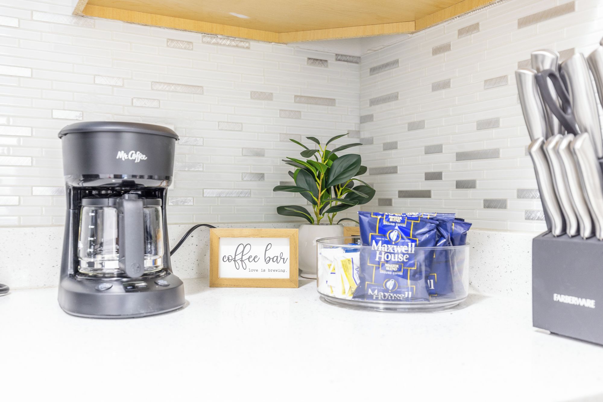 Een koffiezetapparaat, een koffiefilter en een koffiemok op een aanrecht.