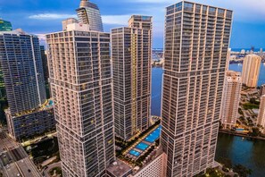 Ein Hochhaus mit Pool auf dem Dach, umgeben von weiteren hohen Gebäuden.