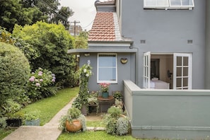 A residential building with a grey exterior, a tiled roof, and a visible number '8' on the wall. - Art deco, light
and airy apartment (Cammeray)