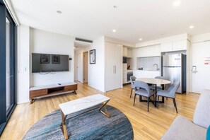 A modern living room with a flat-screen TV, a coffee table, and a sofa. - Coastal Comfort 2Bedroom Luxury Stay w Ocean View (Surfers Paradise)