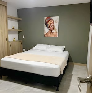 Ein Schlafzimmer mit Bett, Schrank, Ablagefläche mit Dekoration und einem Wandbild.