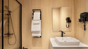 A modern bathroom with a glass-enclosed shower, a white sink, and a towel rack. - Hotel101 Niseko (Abuta District)