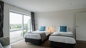 Une chambre d’hôtel avec deux lits, un canapé et une grande fenêtre avec des rideaux.