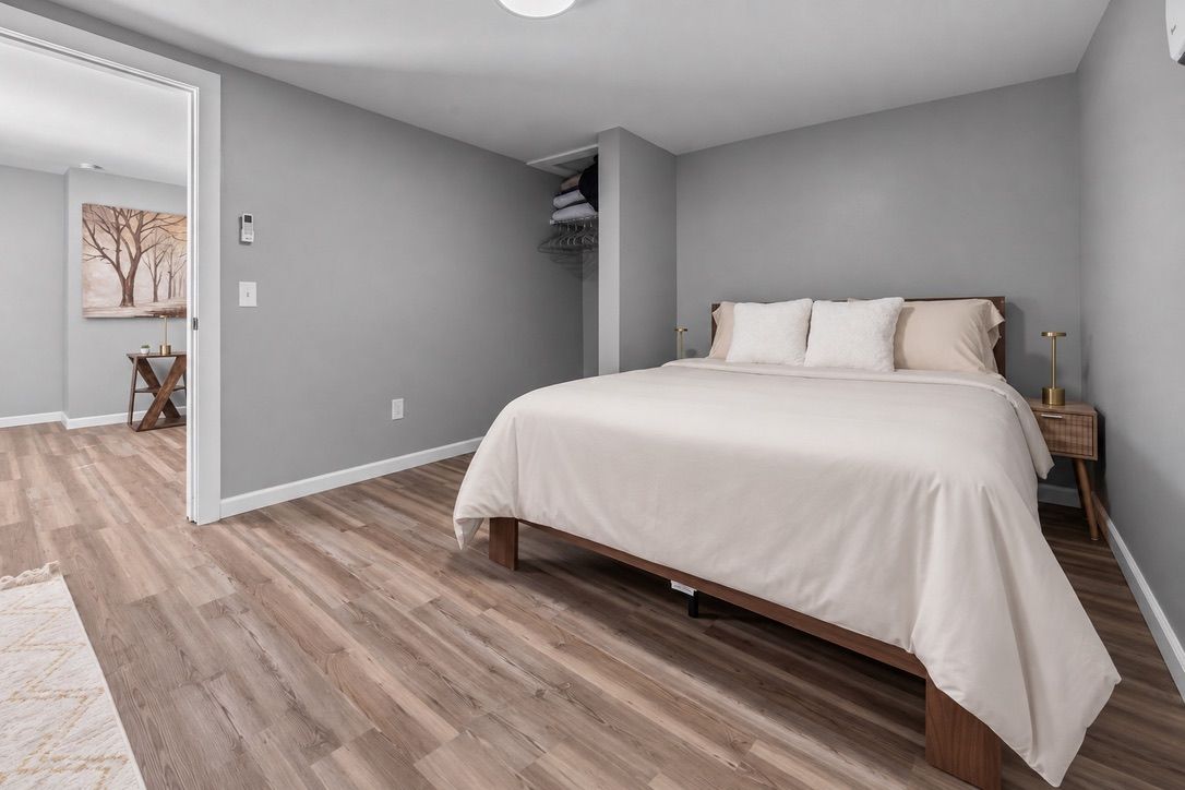 Een slaapkamer met een bed, nachtkastje en kledingkast.