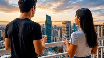 Deux personnes contemplent une vue panoramique sur une ville, avec ses bâtiments modernes et un ciel dégagé.