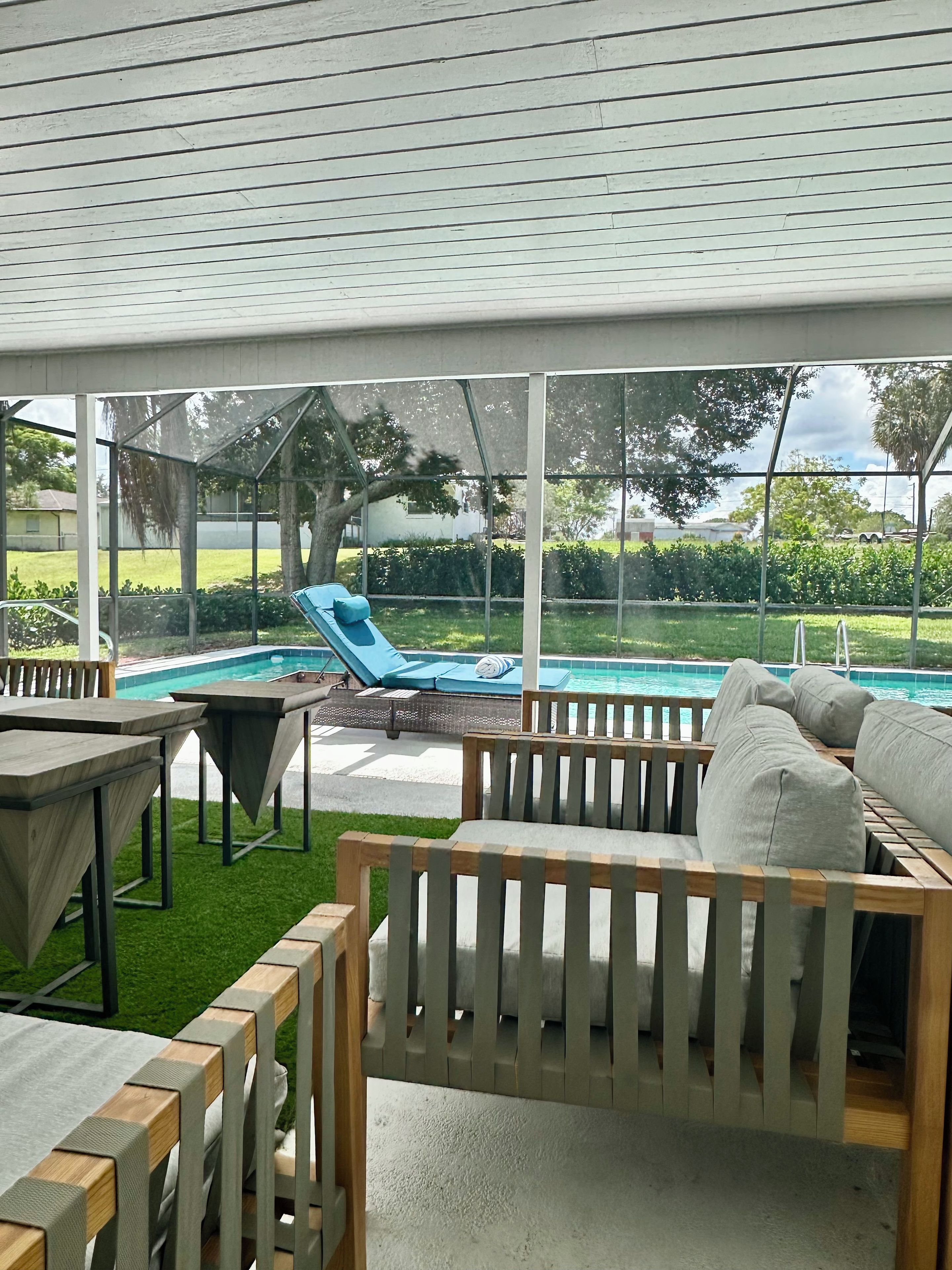 An outdoor patio area with a pool, lounge chairs, and a wooden deck.