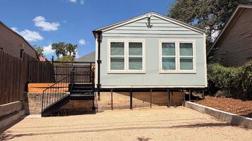 A two-story house with a front porch, a staircase, and a fenced yard.