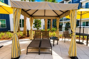 An outdoor seating area with a canopy, chairs, and a table. - Big Home 3 Beds Balcony Pool View Gym Downtown Jax (Jacksonville)