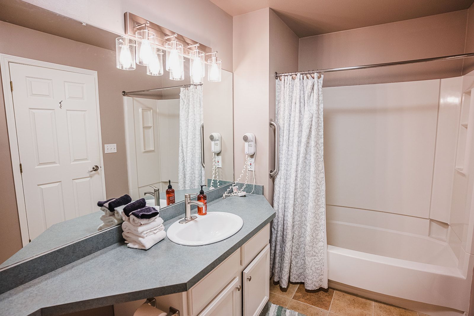 A bathroom with a vanity, a shower, and a toilet.