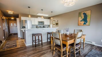 A modern kitchen with white cabinets, a central island, and pendant lighting.