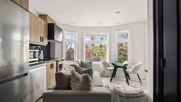 Una cocina moderna con comedor, ventanas amplias y vistas al exterior.