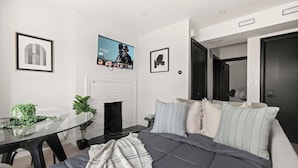 Un dormitorio moderno con cama, mesita de noche y chimenea.