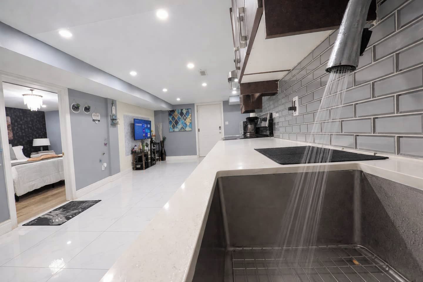 A modern kitchen with a built-in oven, a sink, and a backsplash.