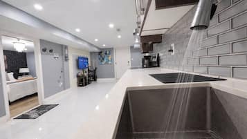 A modern kitchen with a built-in oven, a sink, and a backsplash.