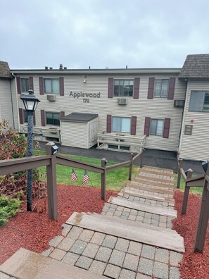Un edificio llamado 'Applewood 170' con una escalera que lleva a un espacio exterior cubierto.