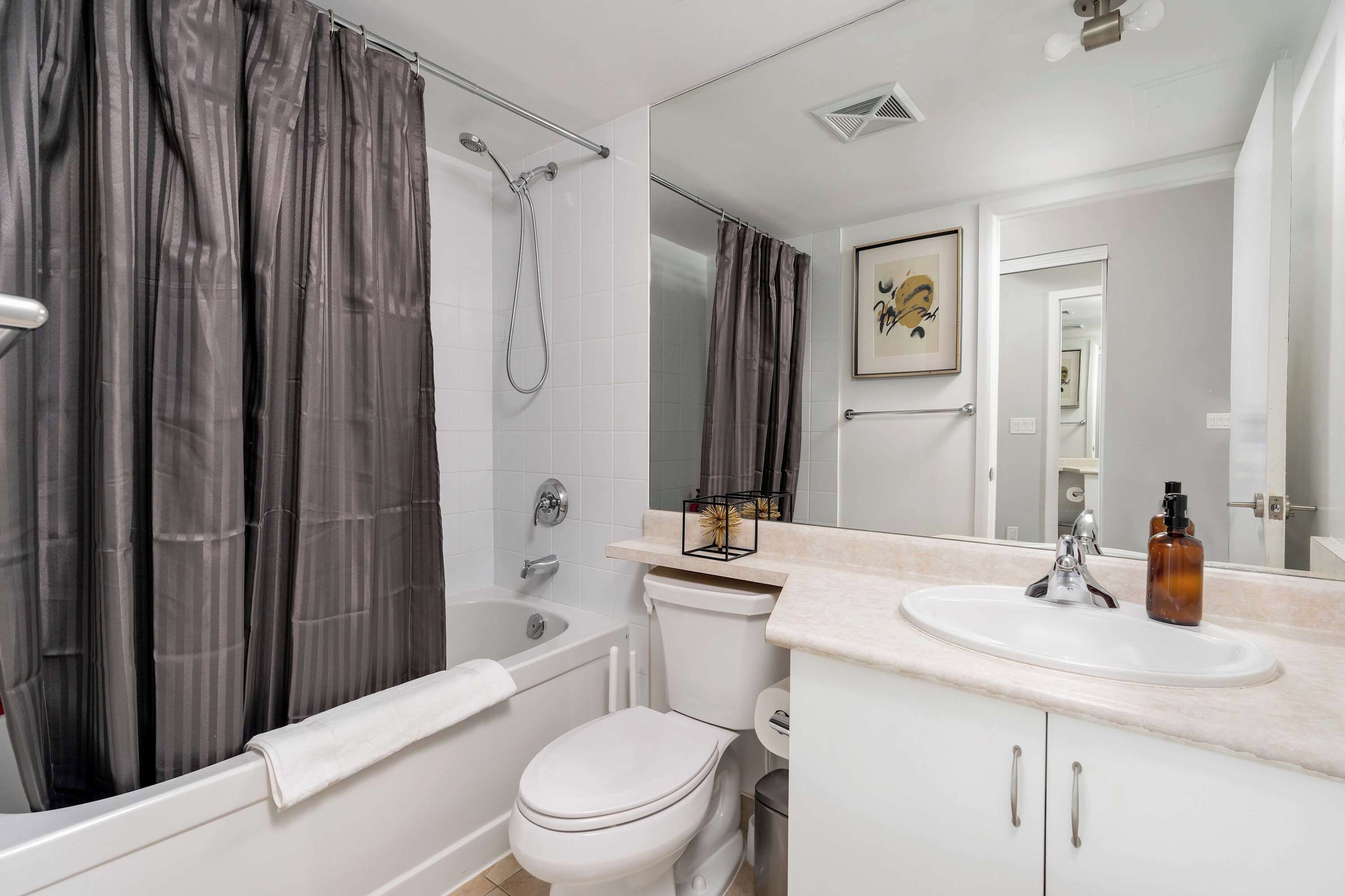 A modern bathroom with a bathtub, toilet, and sink.