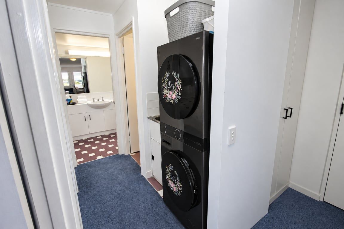 A hallway with a black appliance, a white sink, and a patterned floor.