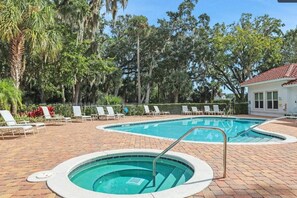 A swimming pool with lounge chairs and a building in the background. - Pool | Jacuzzi | NO EXTRA FEE 5 min to beach (Palm Coast)