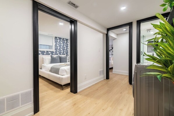 A modern interior with a bed, a wall with a geometric pattern, and a plant.