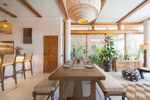 Una zona pranzo con un tavolo in legno, sedie e un lampadario.
