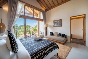 Una camera da letto con un letto grande, un divano e vista sull'esterno.