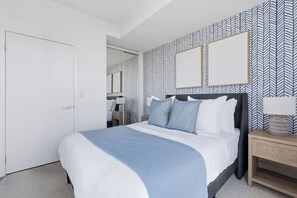 A bedroom with a bed, bedside tables, and a wardrobe.