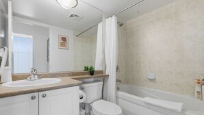 Un baño con lavamanos, inodoro y bañera.