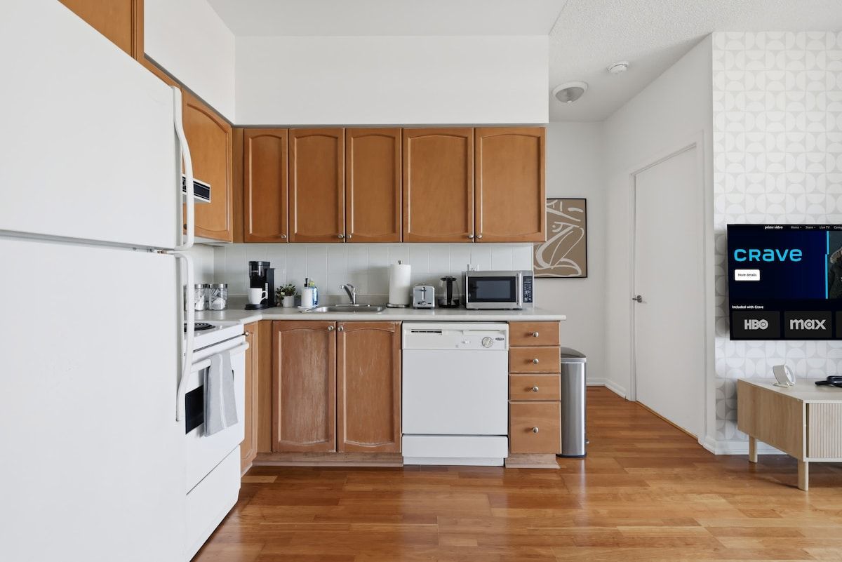 A modern kitchen with wooden cabinets, a white refrigerator, a microwave, and a dishwasher.