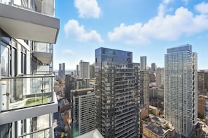 A high-rise building with multiple floors, large windows, and a view of the cityscape. - Stunning Family-Friendly Parking & City Views! | Parking Available (Toronto)