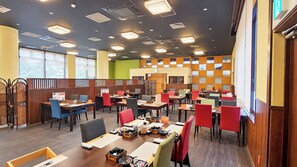 Uma sala de jantar moderna com várias mesas, cadeiras, cabines e diversos tipos de assentos.