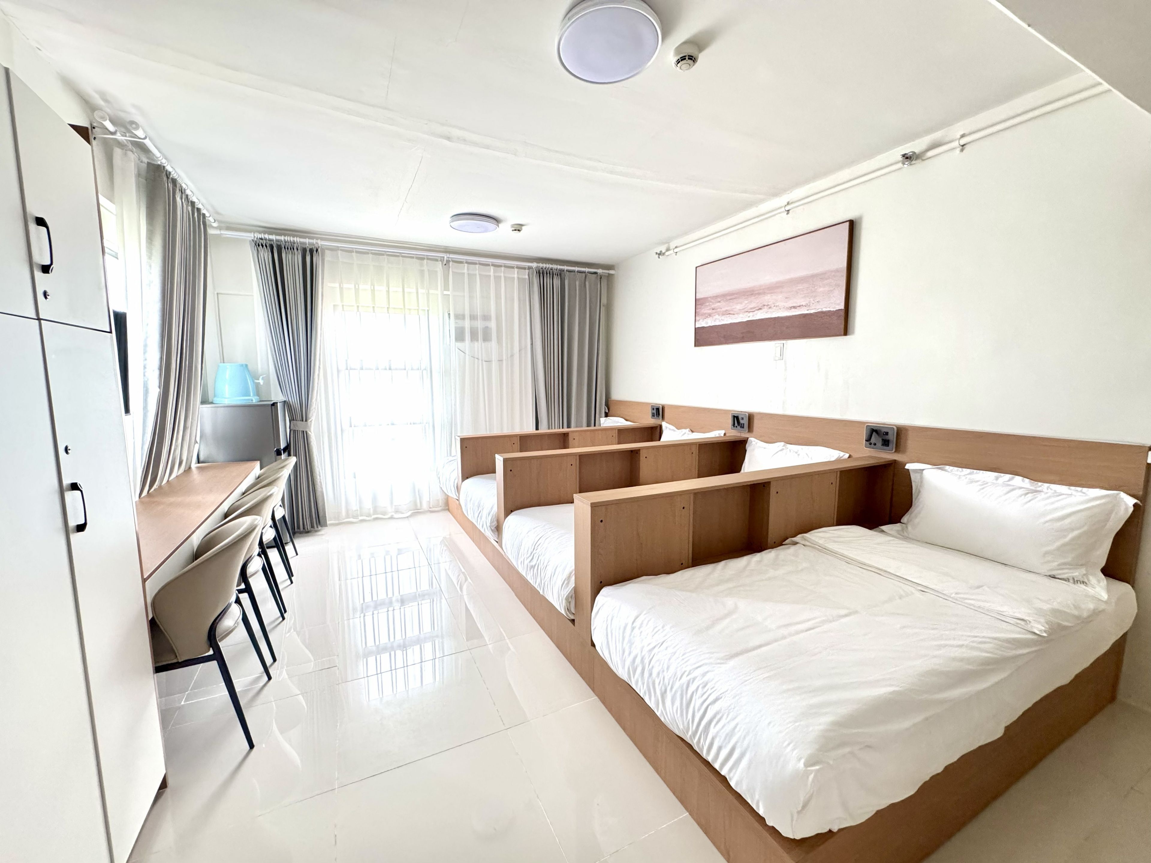 A hotel room with a large bed, a desk, and a chair.