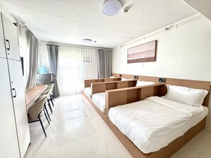 A hotel room with a large bed, a desk, and a chair. - Royal Oceancrest Panglao 1 (Dauis)