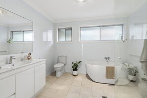 A modern bathroom with a white sink, toilet, and bathtub. - Lakeview@macs by Coast Hosting (MacMasters Beach)