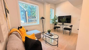 A modern living room with a sofa, coffee table, and a TV in the background.