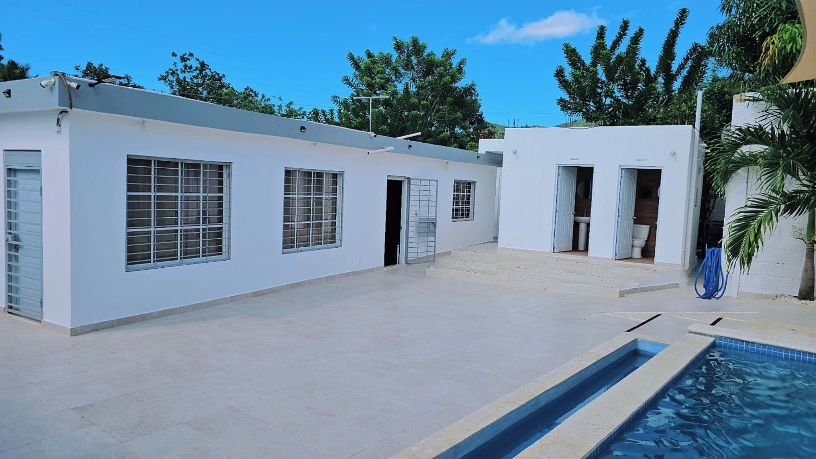 A building with a swimming pool, windows, and doors.