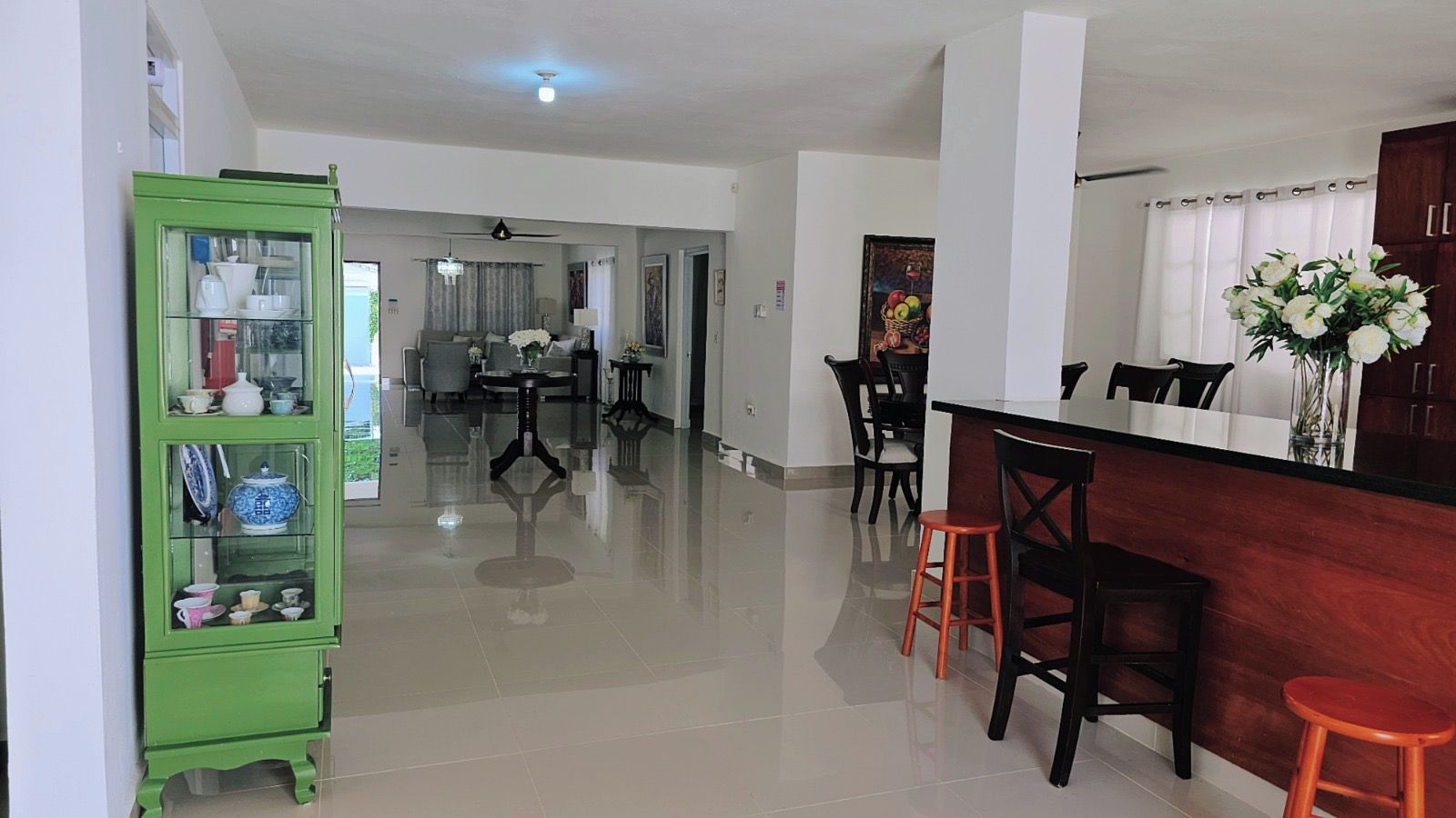 A spacious living area with a dining area, a kitchen, and a bar.