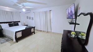 A bedroom with a bed, a bedside table, a mirror, and a television on the wall. - Discover this 3 bed charming country house in Llano de Perez, with AC included (Imbert)