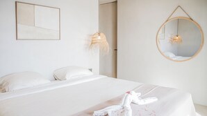 A hotel room with a bed, a hanging light fixture, a wall-mounted mirror, and a framed artwork. - Kas Amare (Kralendijk)
