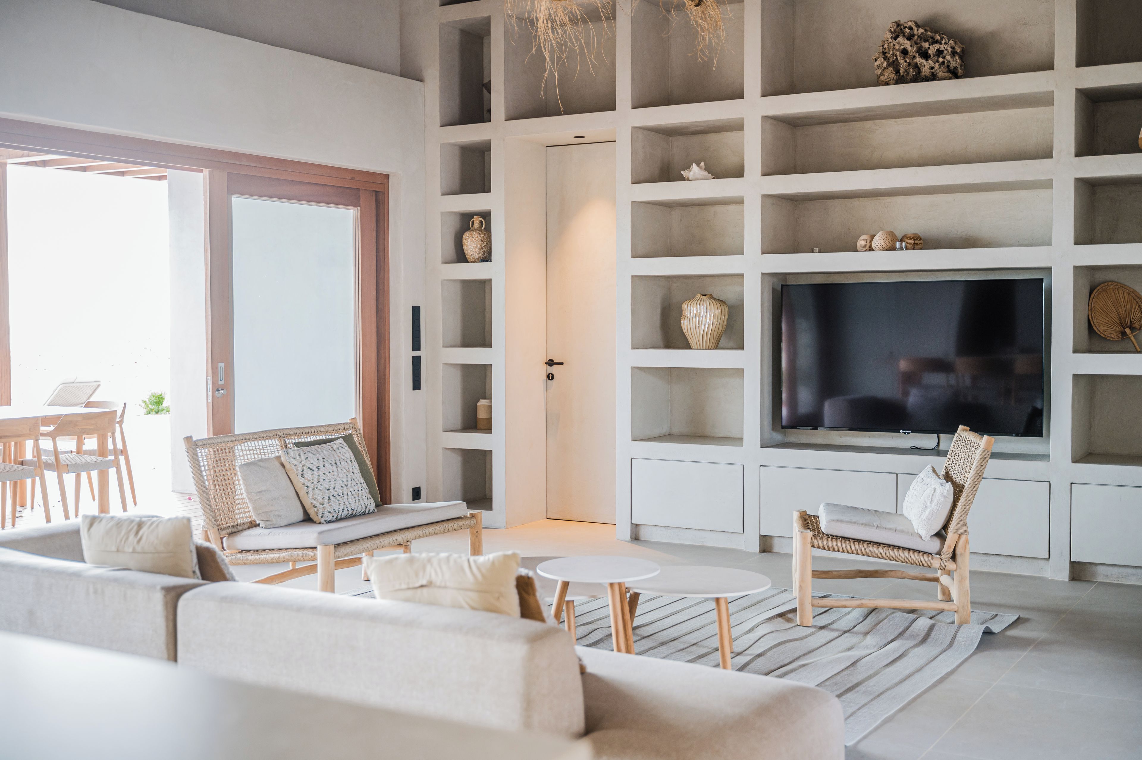 A modern living room with a sofa, chairs, a coffee table, and a TV.