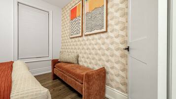 A room with a sofa, a bed with a patterned blanket, and a door.
