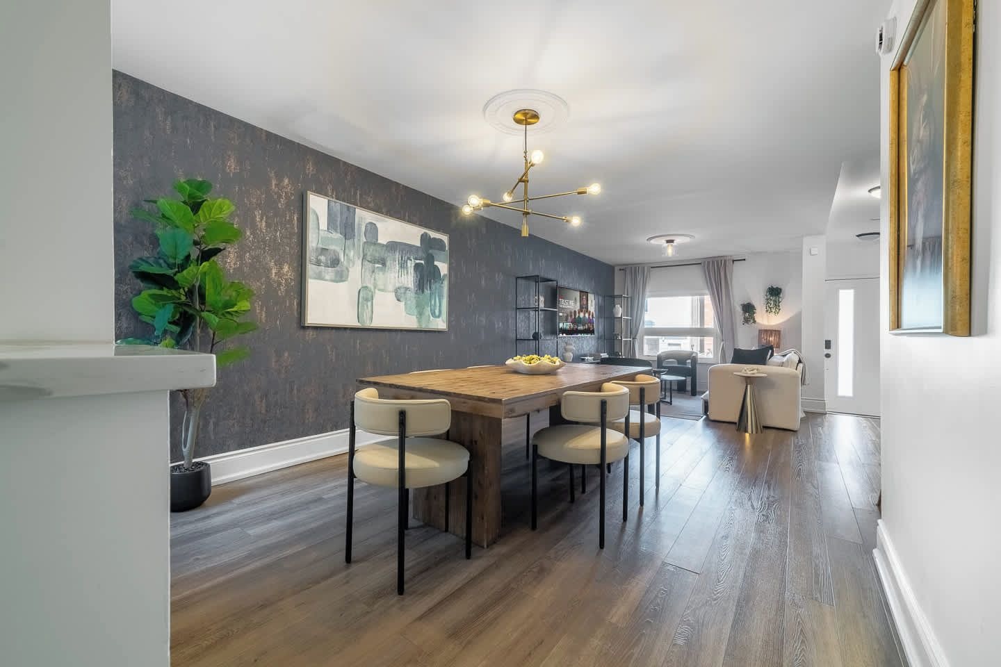 A modern kitchen with a wooden island, bar stools, and a pendant light.