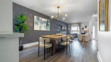 A modern kitchen with a wooden island, bar stools, and a pendant light.